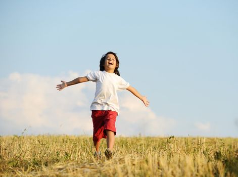 Happy kid running on beautiful field