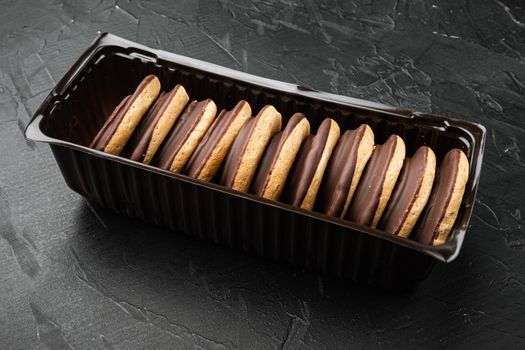 Polish chocolate chip cookies for dessert set, in plastic tray container, on black background