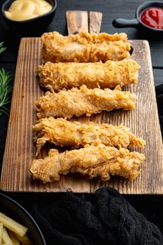 Deep fried crunchy spicy chicken meat on black wooden background.