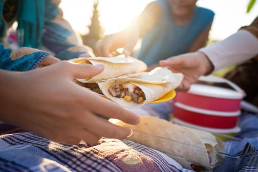 Happy family enjoying picnic on beach near sea