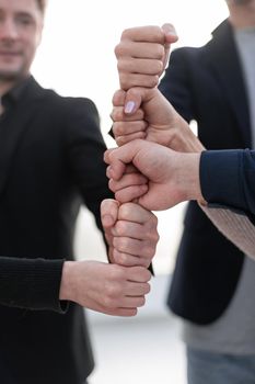 Young people gather fists together as a symbol of unity and achievement