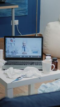 Patient with sickness using video call for telemedicine on laptop asking for medical advice and treatment against disease. Woman talking to doctor on online remote conference for telehealth