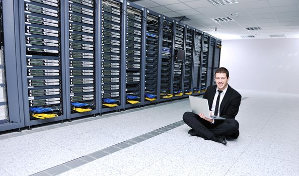 young engeneer business man with thin modern aluminium laptop in network server room