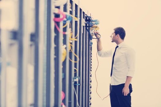 young handsome business man it  engeneer in datacenter server room