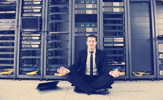 young it  engeneer business man with thin modern aluminium laptop in network server room