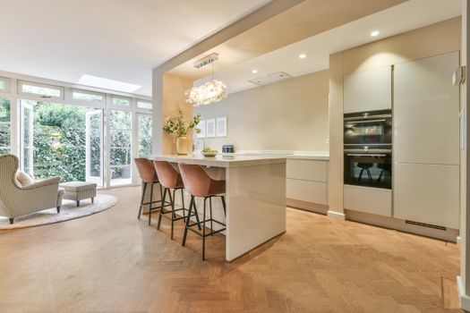 Interior of the light kitchen with modern appliances in a modern flat at daytime