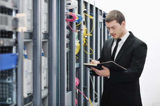 young it engeneer business man with notebook  in network server room