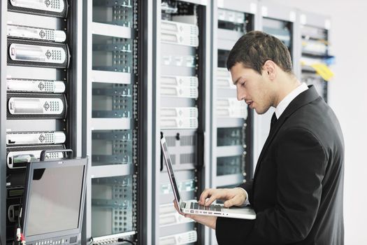 young it  engeneer business man with thin modern aluminium laptop in network server room