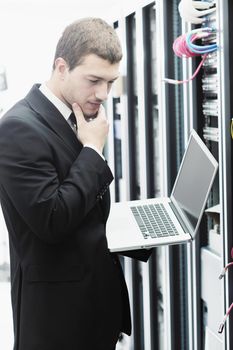 young it  engeneer business man with thin modern aluminium laptop in network server room