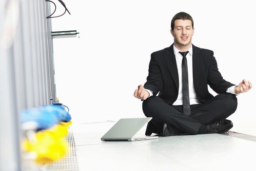 young handsome business man in black suit practice yoga and relax at network server room while representing stress control concept
