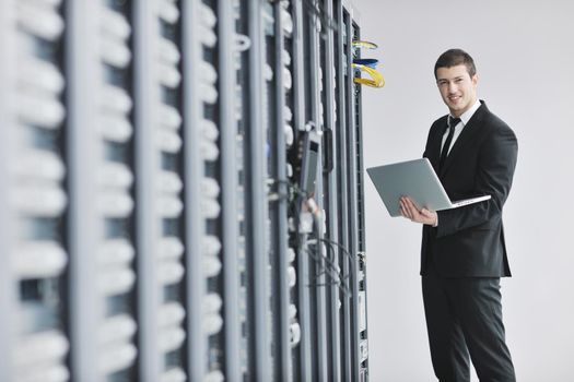 young engeneer business man with thin modern aluminium laptop in network server room