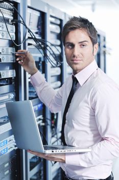 young engeneer business man with thin modern aluminium laptop in network server room