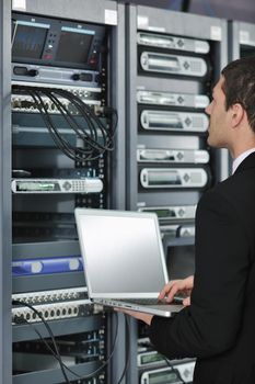 young engeneer business man with thin modern aluminium laptop in network server room