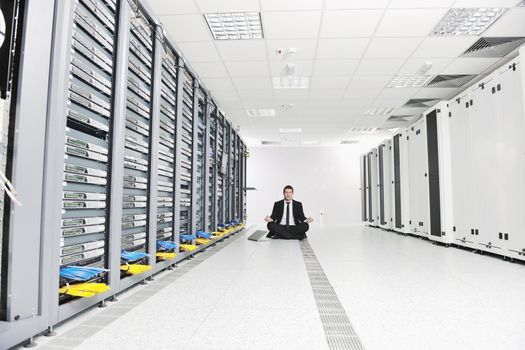 young handsome business man in black suit and tie practice yoga and relax at network server room while representing stres control concept