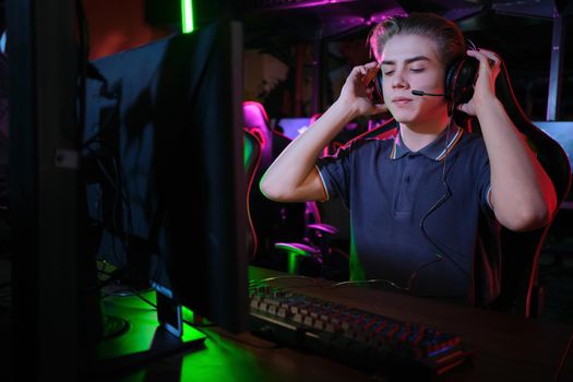 Professional photo of young male caucasian cyber sportsman in gaming club training for important match.