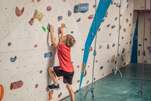 Boy at the climbing wall without a helmet, danger at the climbing wall.