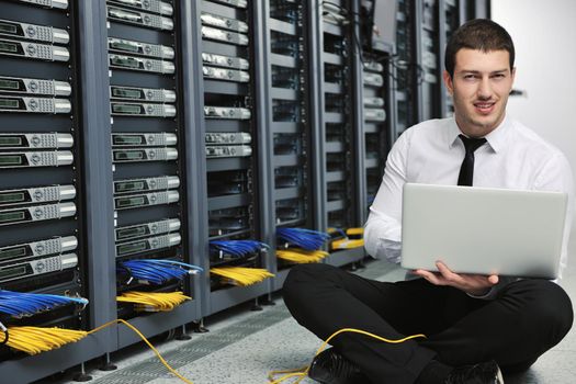 young engeneer business man with thin modern aluminium laptop in network server room