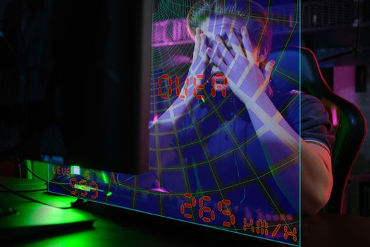 Photo of professional young caucasian gamer playing online on his PC in gaming club or cyber arena. He looks displeased and upset. Game plan went wrong. laser screen, projector, augmented reality, AR, VR
