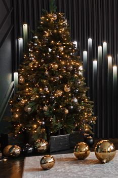 Christmas interior with a beautiful Christmas tree, sofa, light bulbs and dark background.