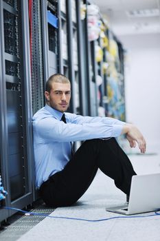 young engeneer business man with thin modern aluminium laptop in network server room