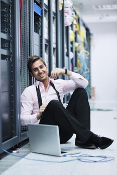 young engeneer business man with thin modern aluminium laptop in network server room