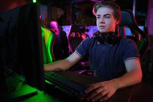 Professional photo of young male caucasian cyber sportsman in gaming club training for important match.