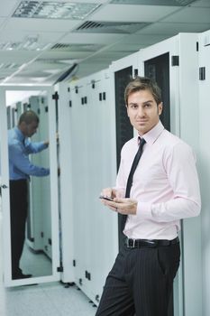 young business man computer science engeneer talking by cellphone at network datacenter server room asking  for help and fast solutions and services