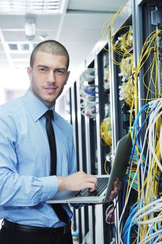 young engeneer business man with thin modern aluminium laptop in network server room