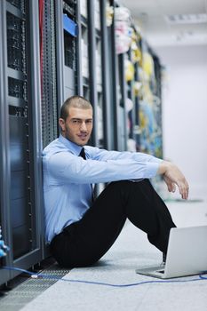 young engeneer business man with thin modern aluminium laptop in network server room