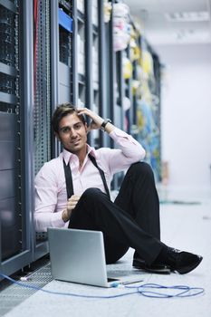 young engeneer business man with thin modern aluminium laptop in network server room