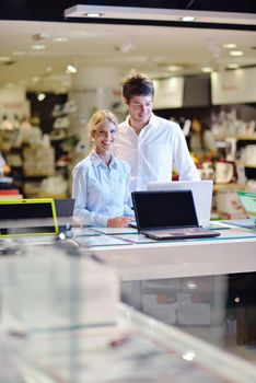 people in consumer electronics  retail store looking at latest laptop, television and photo camera to buy