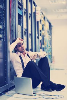 young engeneer business man with thin modern aluminium laptop in network server room