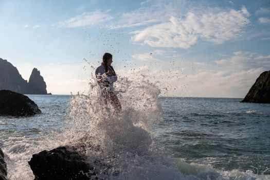 Selective focus. Happy carefree sensual woman with long hair in black swimwear posing at sunset beach. Silhouette of young beautiful playful positive woman outdoor. Summer vacation and trip concept.