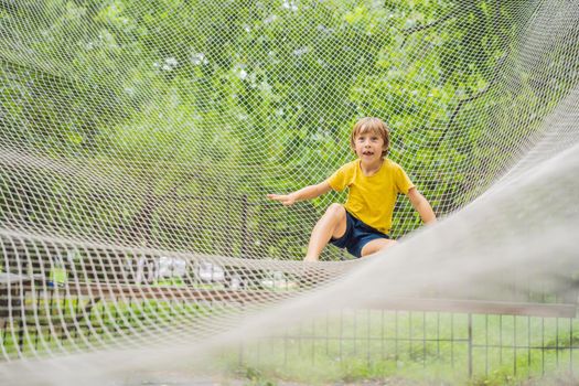 practice nets playground. boy plays in the playground shielded with a protective safety net. concept of children on line, kid in social networks. blurred background, blurred motion due to the concept.
