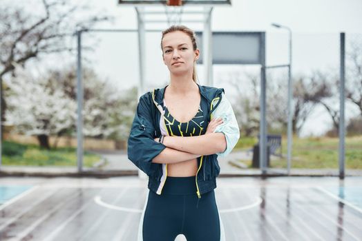 Beautiful and strong. Confident young disabled woman in sport wear keeping arms crossed while standing outdoors. Sport concept. Healthy lifestyle
