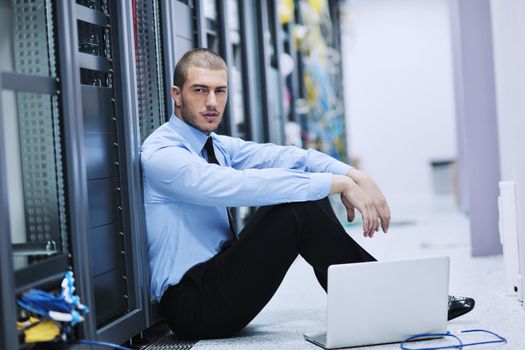 young engeneer business man with thin modern aluminium laptop in network server room