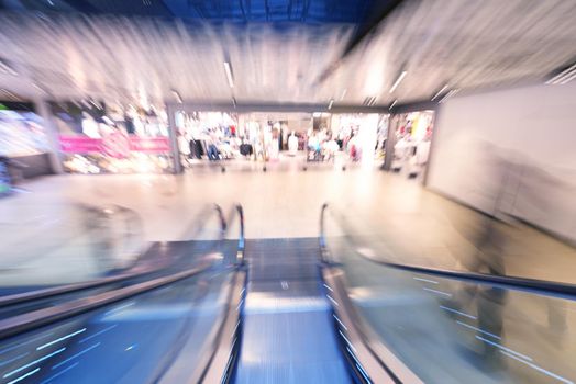 Shopping mall center escalators. Zoom blur movement.