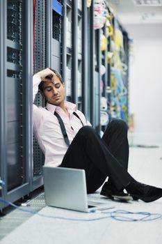 young engeneer business man with thin modern aluminium laptop in network server room