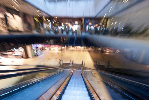 Shopping mall center escalators. Zoom blur movement.