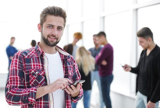 close up. smiling young designer reading a message on his smartphone