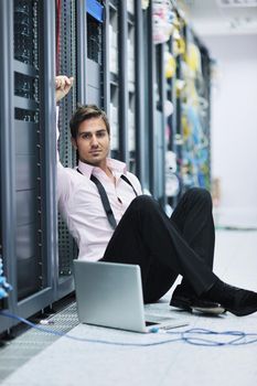 young engeneer business man with thin modern aluminium laptop in network server room