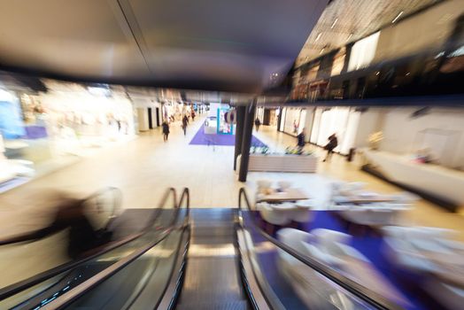 Shopping mall center escalators. Zoom blur movement.