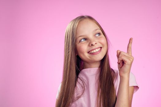 cute girl with long hair on pink background lifestyle childhood. High quality photo