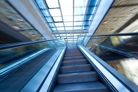 Shopping mall center escalators. Zoom blur movement.