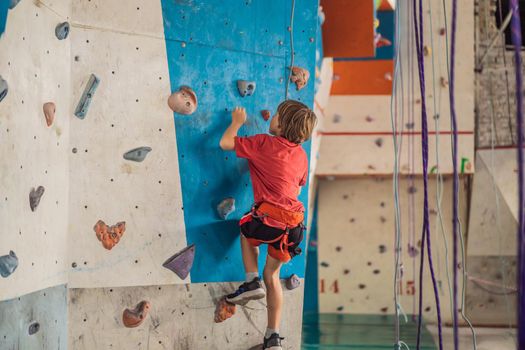 Boy at the climbing wall without a helmet, danger at the climbing wall.