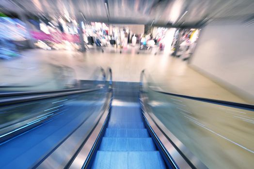 Shopping mall center escalators. Zoom blur movement.