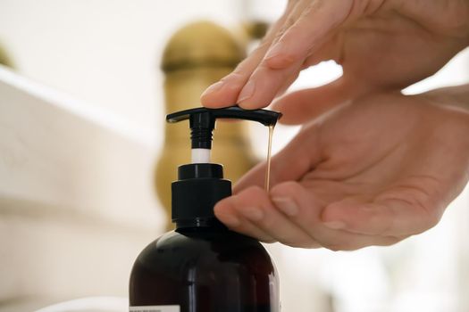 The girl washes her hands with liquid soap under water, the woman takes care of her health and cleanliness, disinfects her hands.