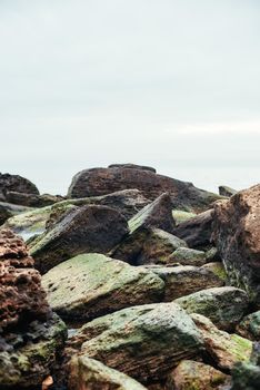 Vertical close up photo of big boulders on the beach. Nature landscape. Sky and rocks