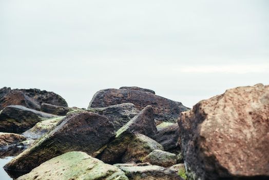 Close up photo of big boulders on the beach. Nature landscape. Sky and rocks