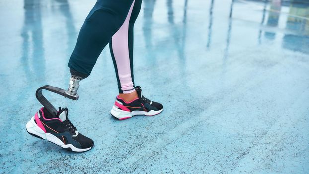 Wake up and workout. Cropped image of disabled athlete woman with prosthetic leg standing on stadium. Sport concept. Disabled Sportsman